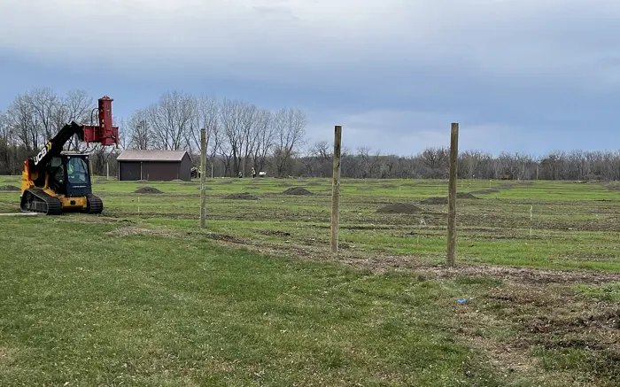 Row of new fence posts set across a field