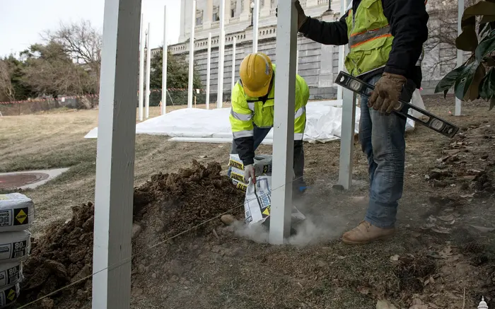Crew setting a steel fence post